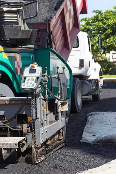 Pavement truck laying fresh asphalt