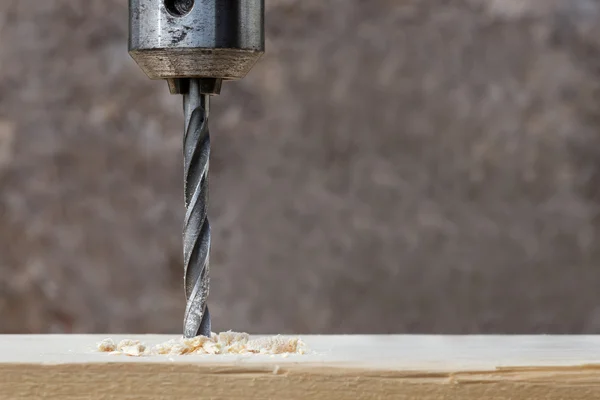 Drilling wooden plank with hand drill