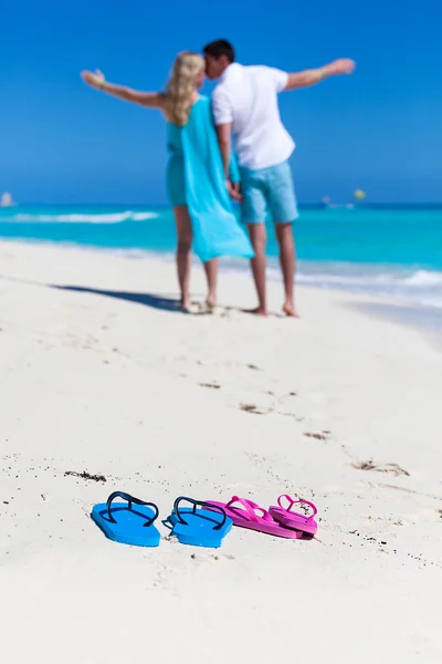 Beach flip-flops on romantic couple background