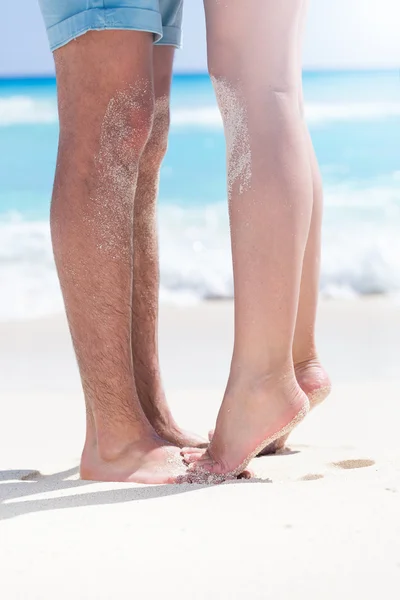 Couple of male and female legs on beach