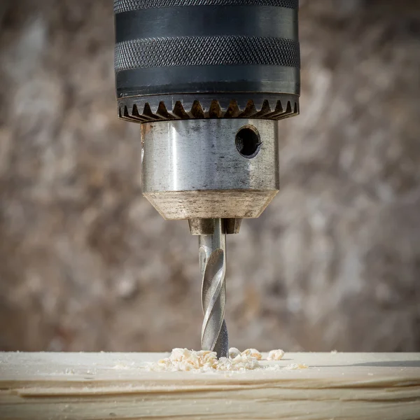 Drilling wooden plank with hand drill