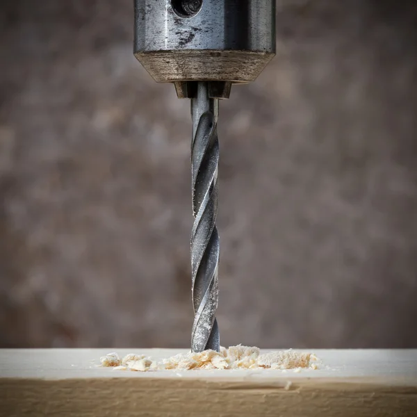 Drilling wooden plank with hand drill