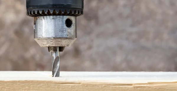 Drilling wooden plank with hand drill