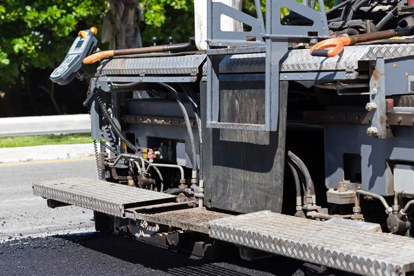 Pavement truck laying fresh asphalt