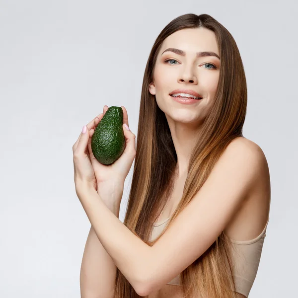 Beautiful Woman with Clean Fresh Skin holding avocado