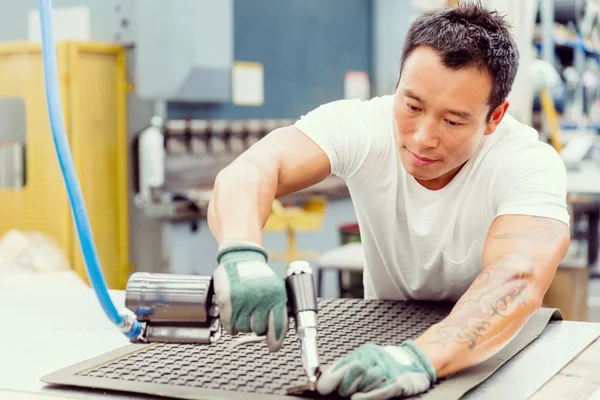 Asian worker in production plant on the factory floor