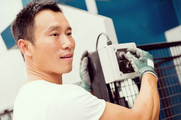 Asian worker in production plant on the factory floor