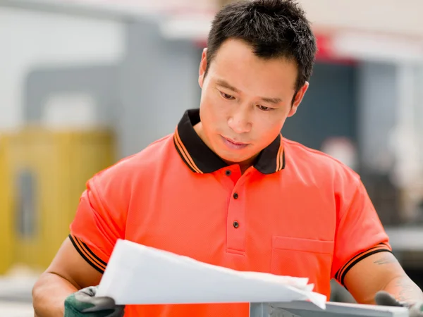 Asian worker in production plant on the factory floor