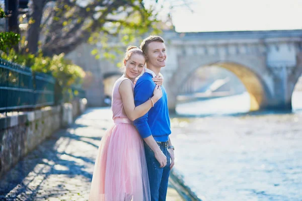 Beautiful romantic couple in Paris near the river Seine