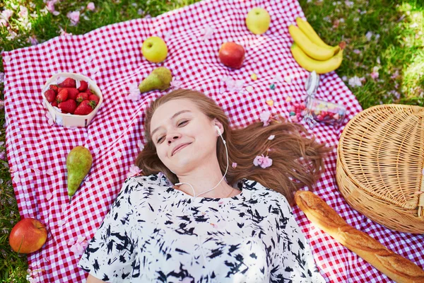 Beautiful young woman having picnic in park