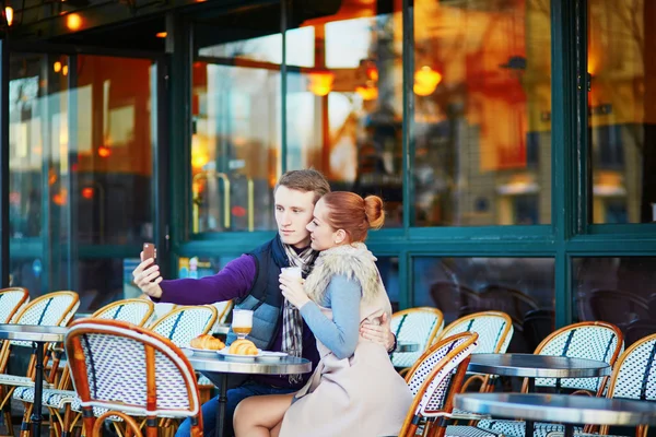 Romantic couple taking selfie in cafe in Paris, France