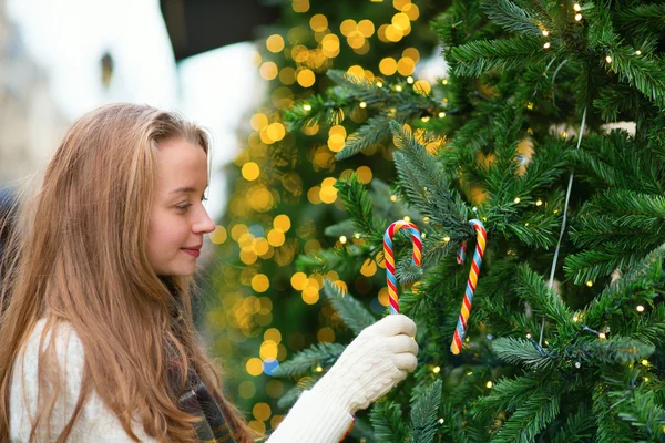 Girl decorating Christmas tree with candies