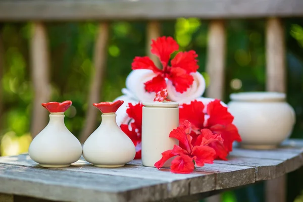 Spa setting with towels and red hibiscus flowers