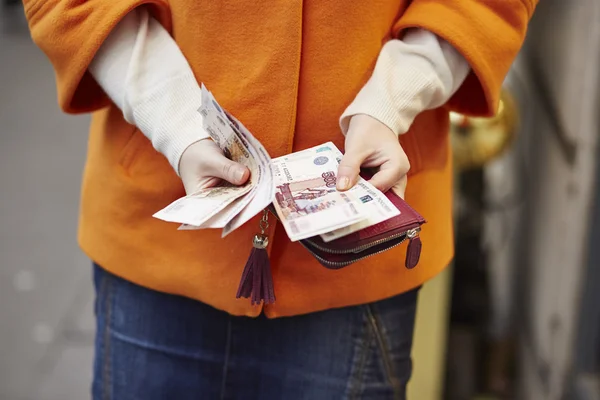 Woman hands holding purse with Russian roubles