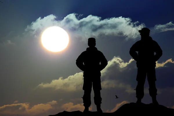 Silhouette of soldier with rifle against a sunset