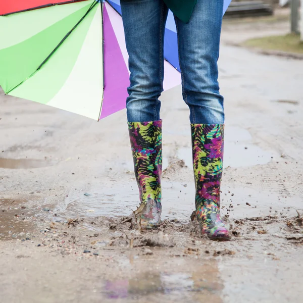 Woman with rain boots jumps