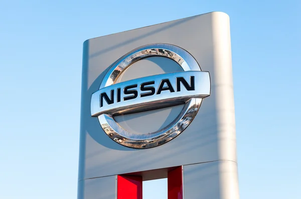 Official dealership sign of Nissan against blue sky