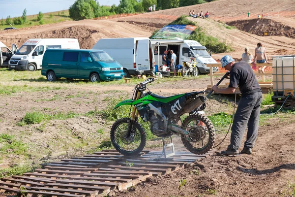 Man washing a race bike after the competition in motocross