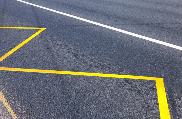 Yellow Bus Stop sign painted on the asphalt closeup