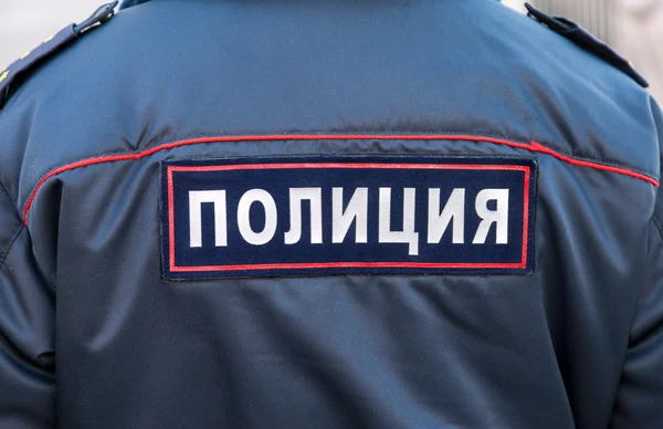 Midsection of russian policeman in uniform. Text on russian: \