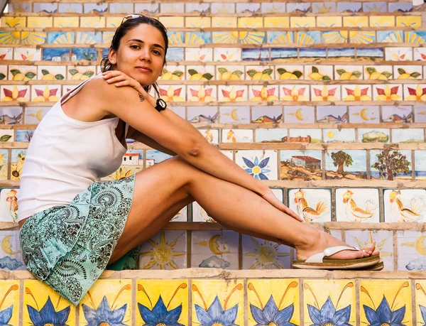 Beautiful girl on the stairs decorated with ceramic tiles