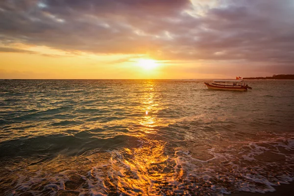 Calm ocean with boat on sunrise