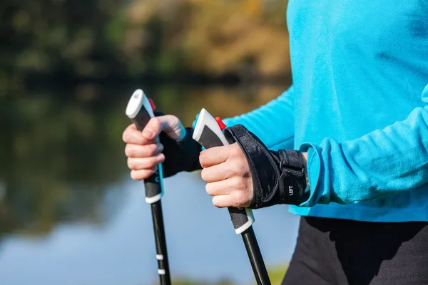 Closeup of womans hand holding nordic walking poles