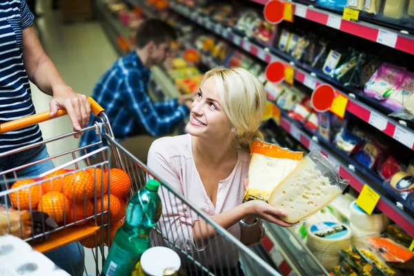 Couple choosing cheese at shop