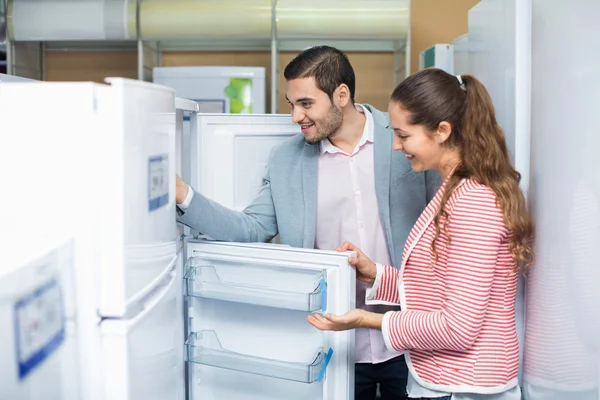 Couple looking at large fridges