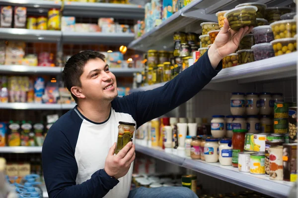 Young man buying tinned food