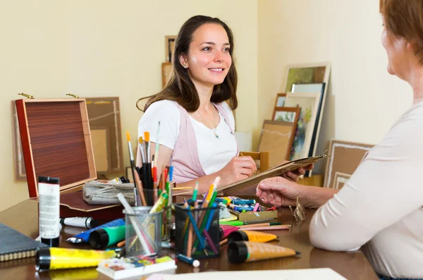 Female artist painting portrait of woman