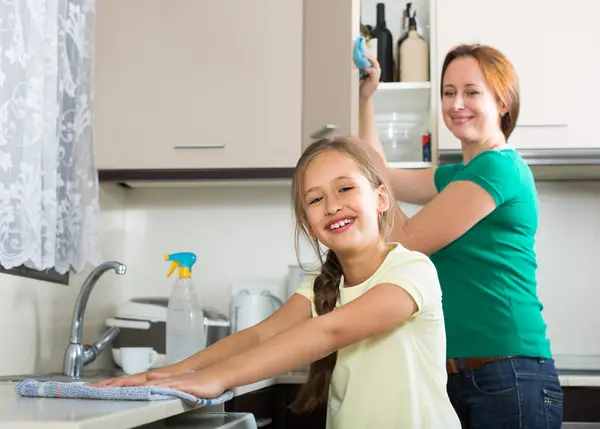 Girl and mom tidy kitchen up