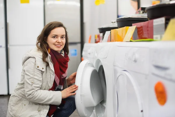 Positive female customer looking at dryers