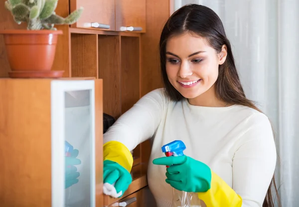Girl in jersey cleaning furniture