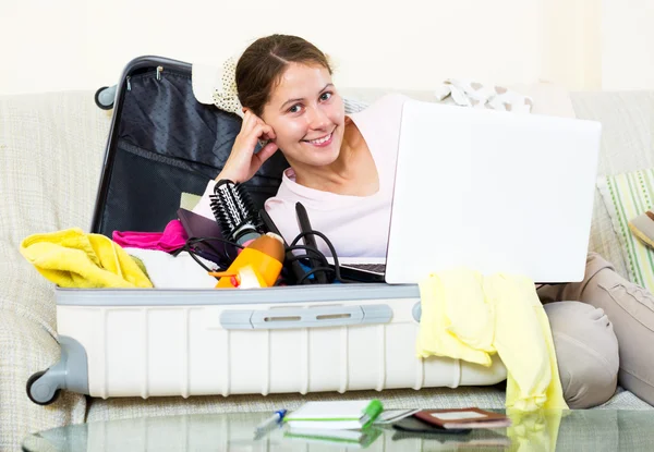 Woman with packed baggage and notes