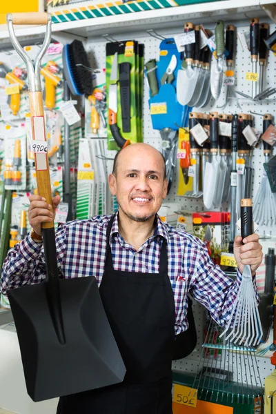 Salesman with garden tools in store