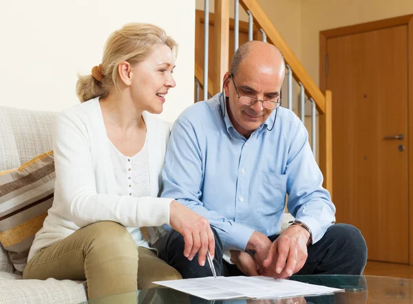 Mature couple with documents at home