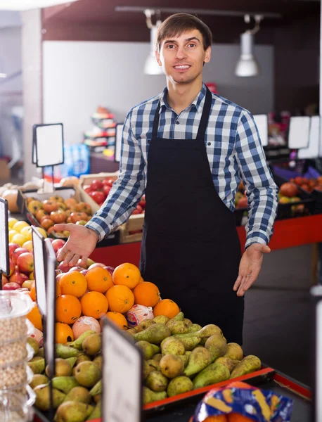 Grocery worker selling seasonal fruits