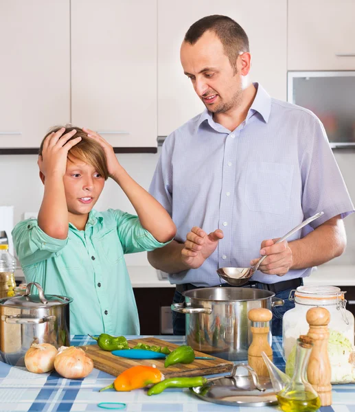 Father and son cooking dinner