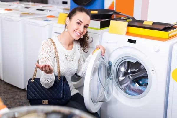 Woman choosing new laundry machine