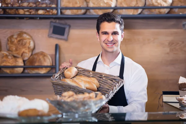 Man bakery employee offering bread and pastry