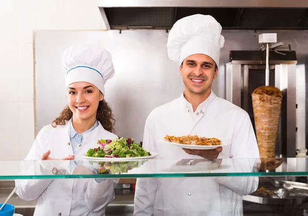 Chefs with kebab and salad