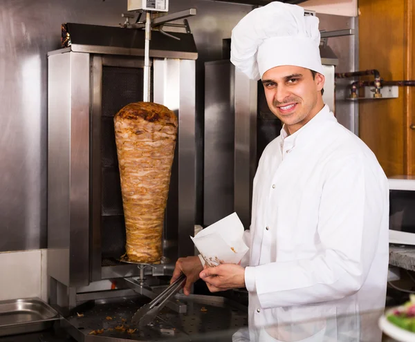 Chef cutting meat for kebab