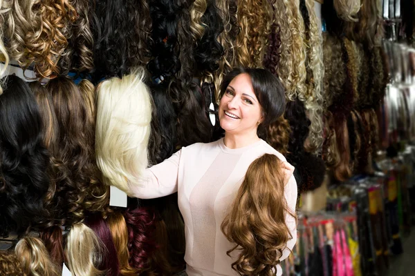 Female shop assistant selling natural hail ponytails