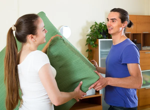 Couple moving furniture in room