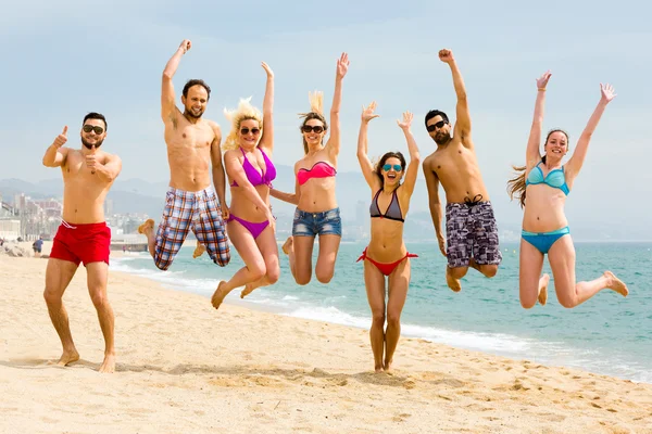 Happy people jumping on a beach