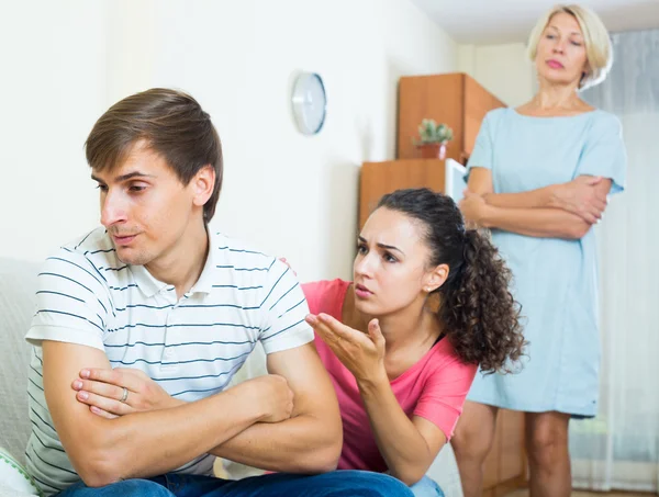 Wife and mother-in-law argying with young man