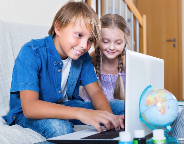 Smiling kids internet chatting on notebook