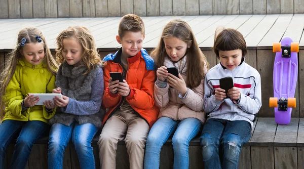 Kids sitting with mobile devices