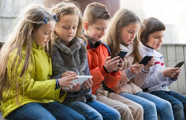 Kids sitting with mobile devices